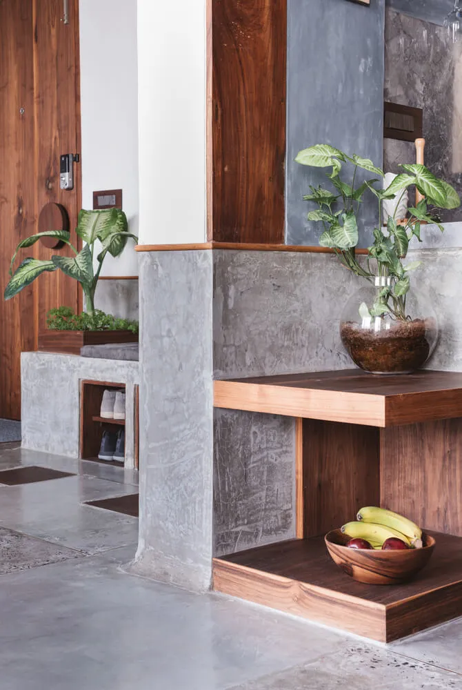 A modern entryway featuring concrete and walnut wood materials.