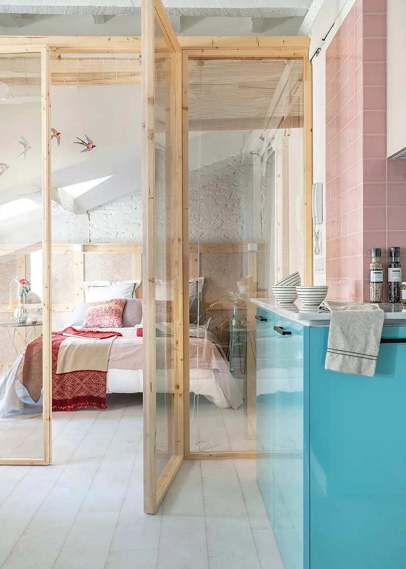 A modern kitchen with pink tiles and wooden finishes, showcasing contemporary design.