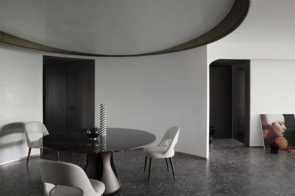 Modern minimalist dining room with a round marble table and white chairs