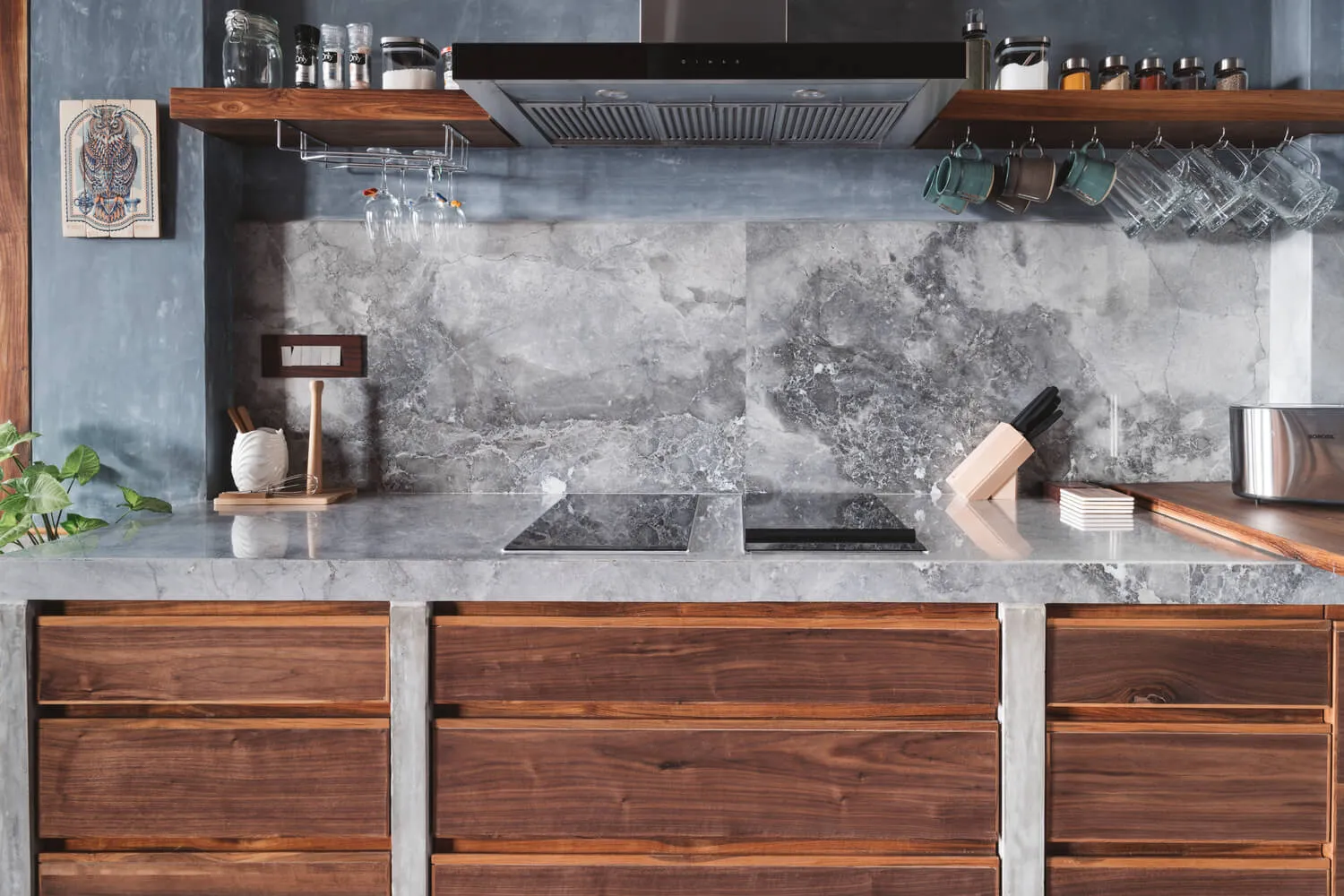 Modern minimalist kitchen featuring granite countertops and a marble backsplash.