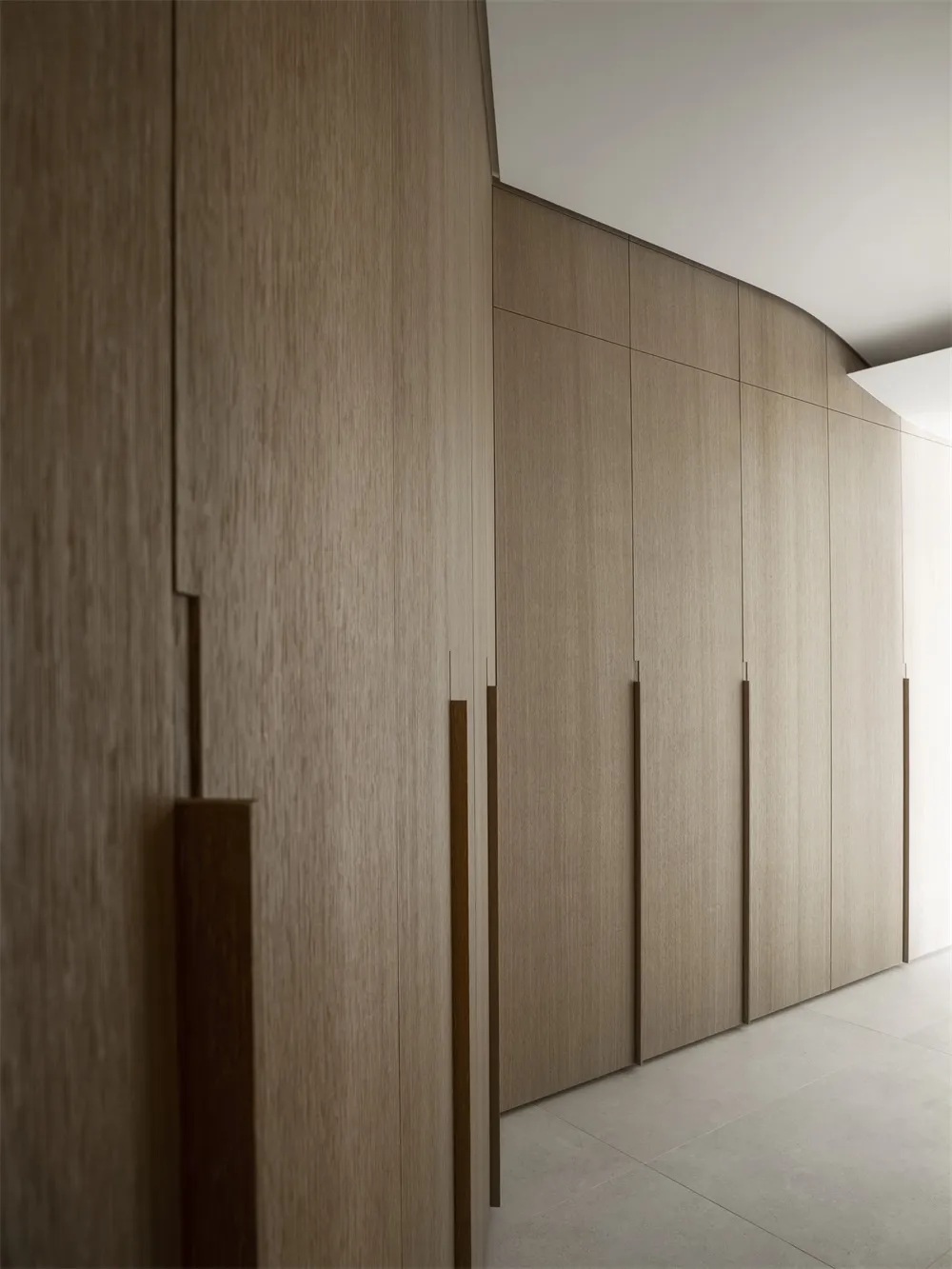 A modern minimalist interior featuring wooden cabinets, emphasizing sleek design and clean lines.