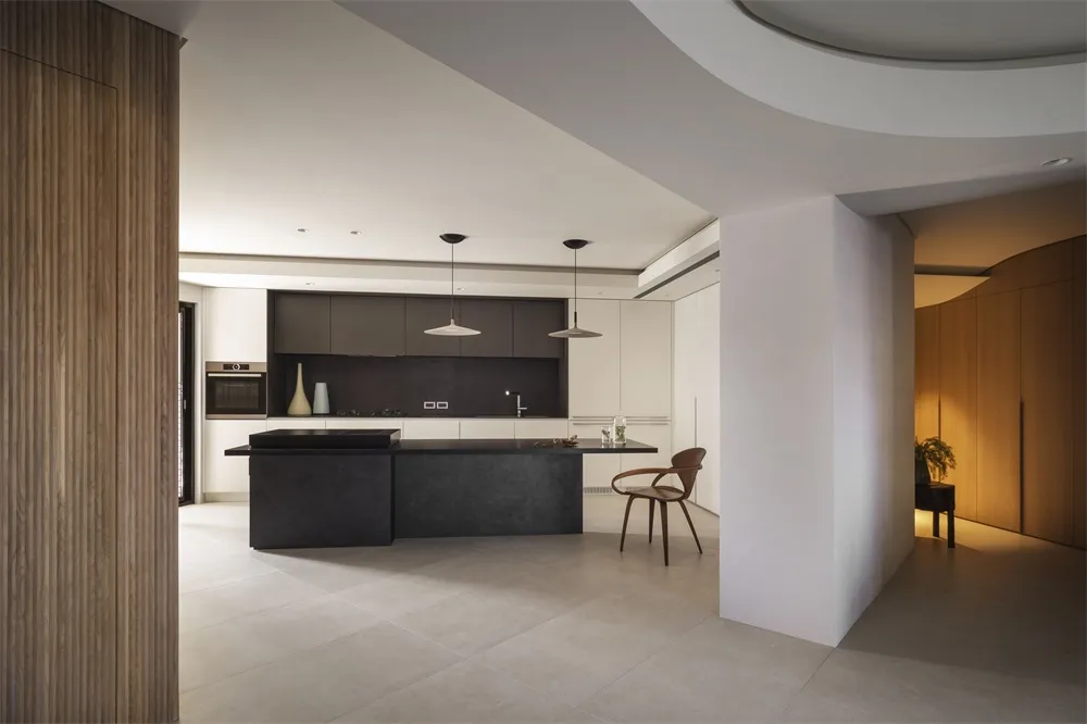 Modern minimalist kitchen featuring a black countertop and concrete floor.