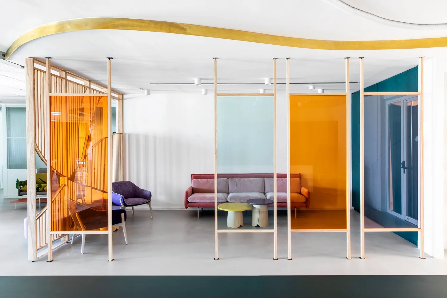 Modern office lobby with colorful transparent glass walls and contemporary furniture.