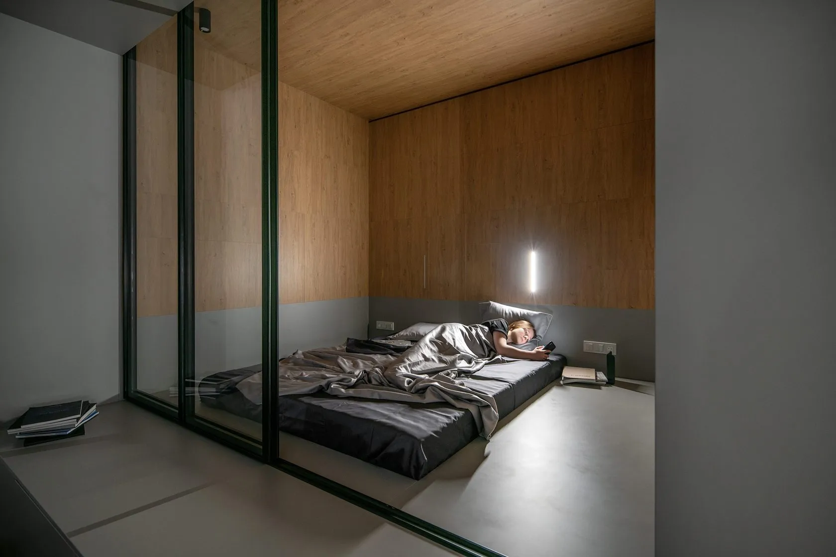 A minimalist bedroom featuring a wooden bed and sleek design.