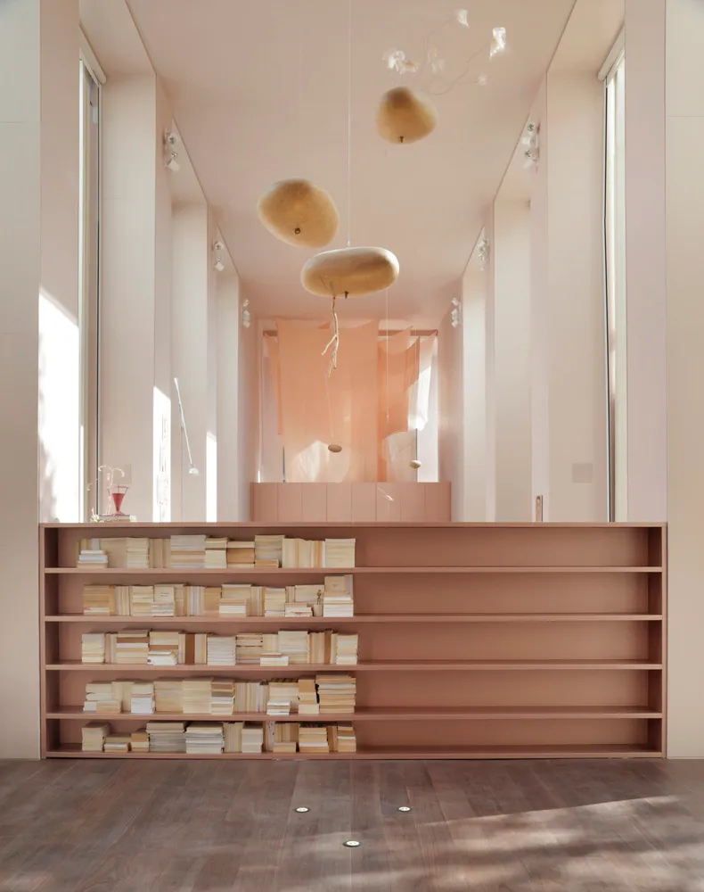 A minimalist library with wooden shelves and soft lighting features.