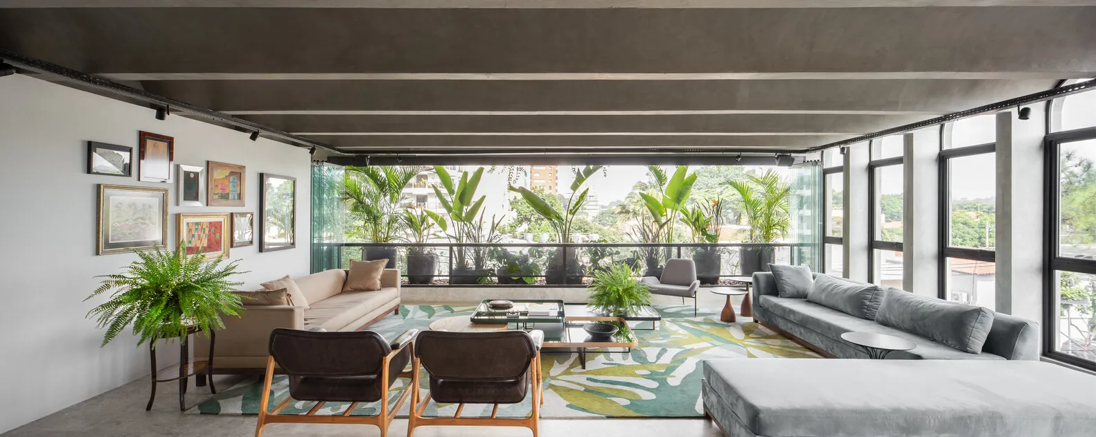 Modern living room with concrete floors and walls, featuring contemporary furniture and plants.