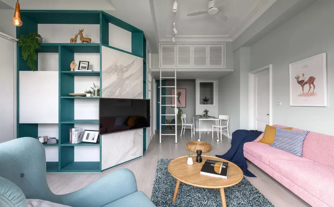 A modern living room featuring a blue and pink color scheme, with composite walls and a comfortable seating area, including a