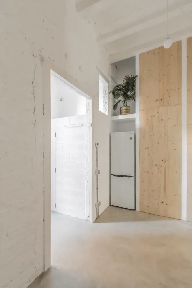 Modern, minimalist apartment interior with concrete flooring and white walls.