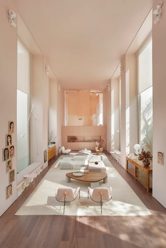 Modern minimalist living room with wooden furnishings and a large rug.