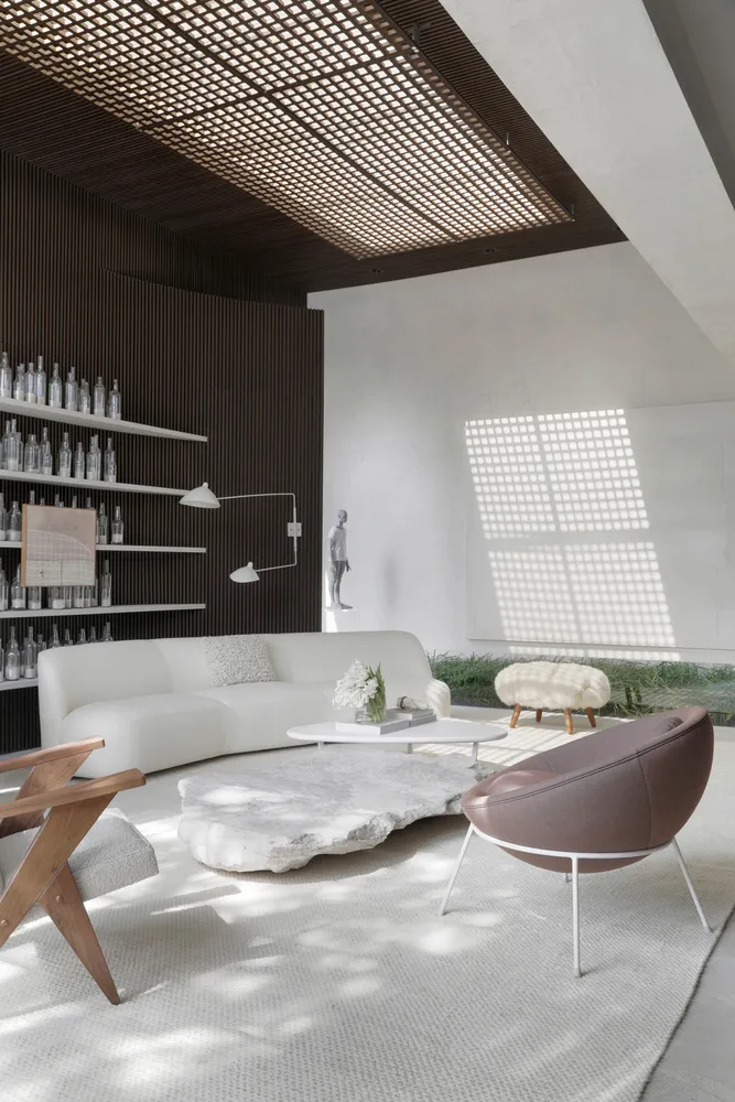 A modern living room featuring a white sofa, stone coffee table, and various lighting elements.