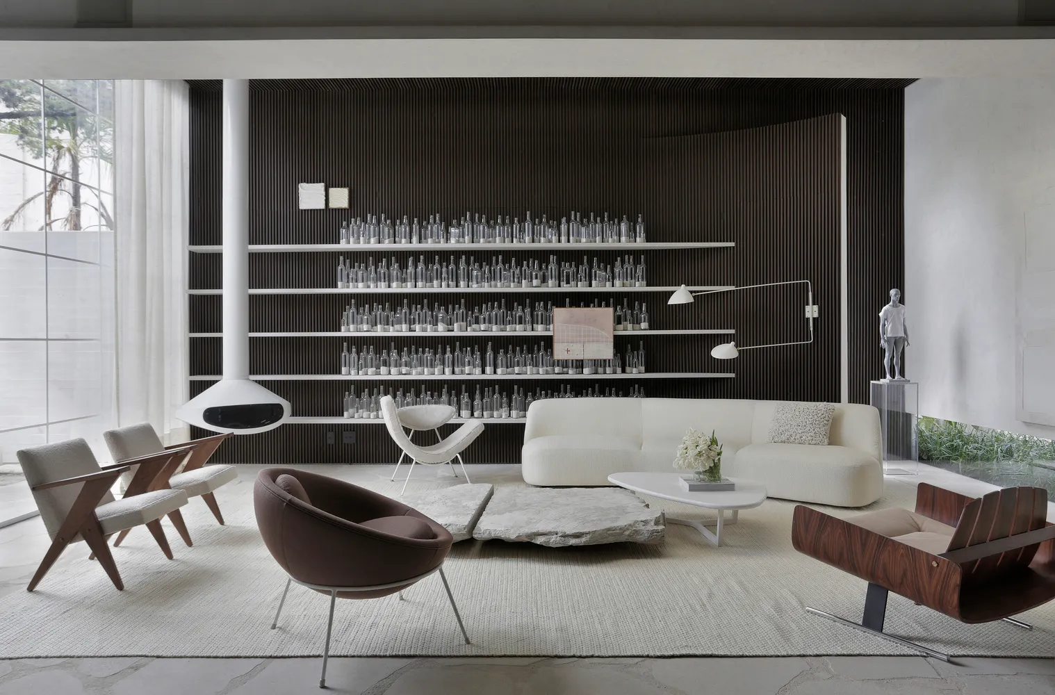 Modern living room with white and brown furniture, a white stone coffee table, and a black floor lamp on a white rug. The wal