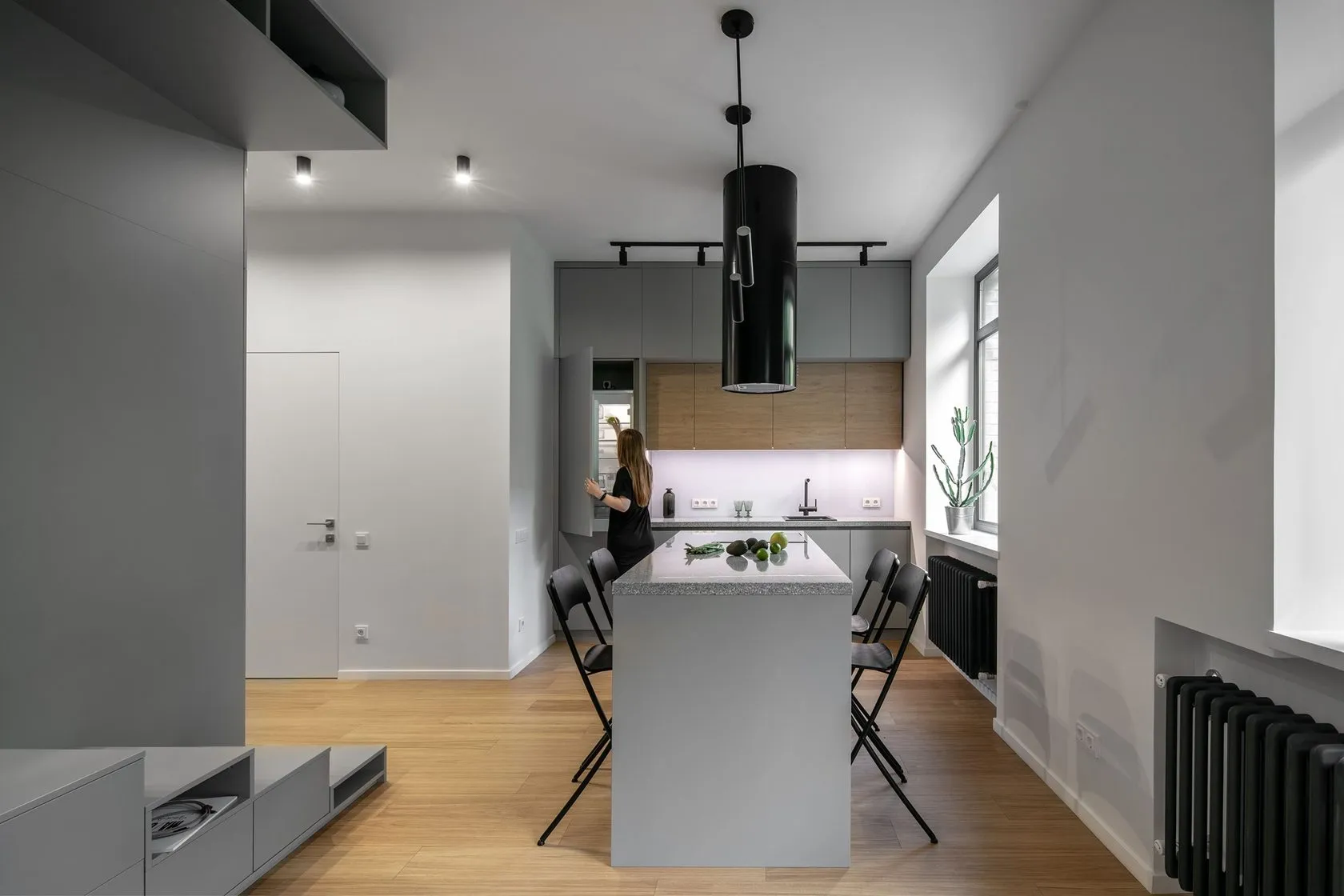A minimalist kitchen with white marble countertops and stainless steel appliances.