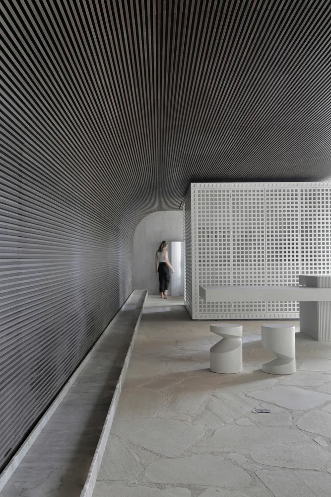 A minimalist interior design featuring concrete walls and flooring.