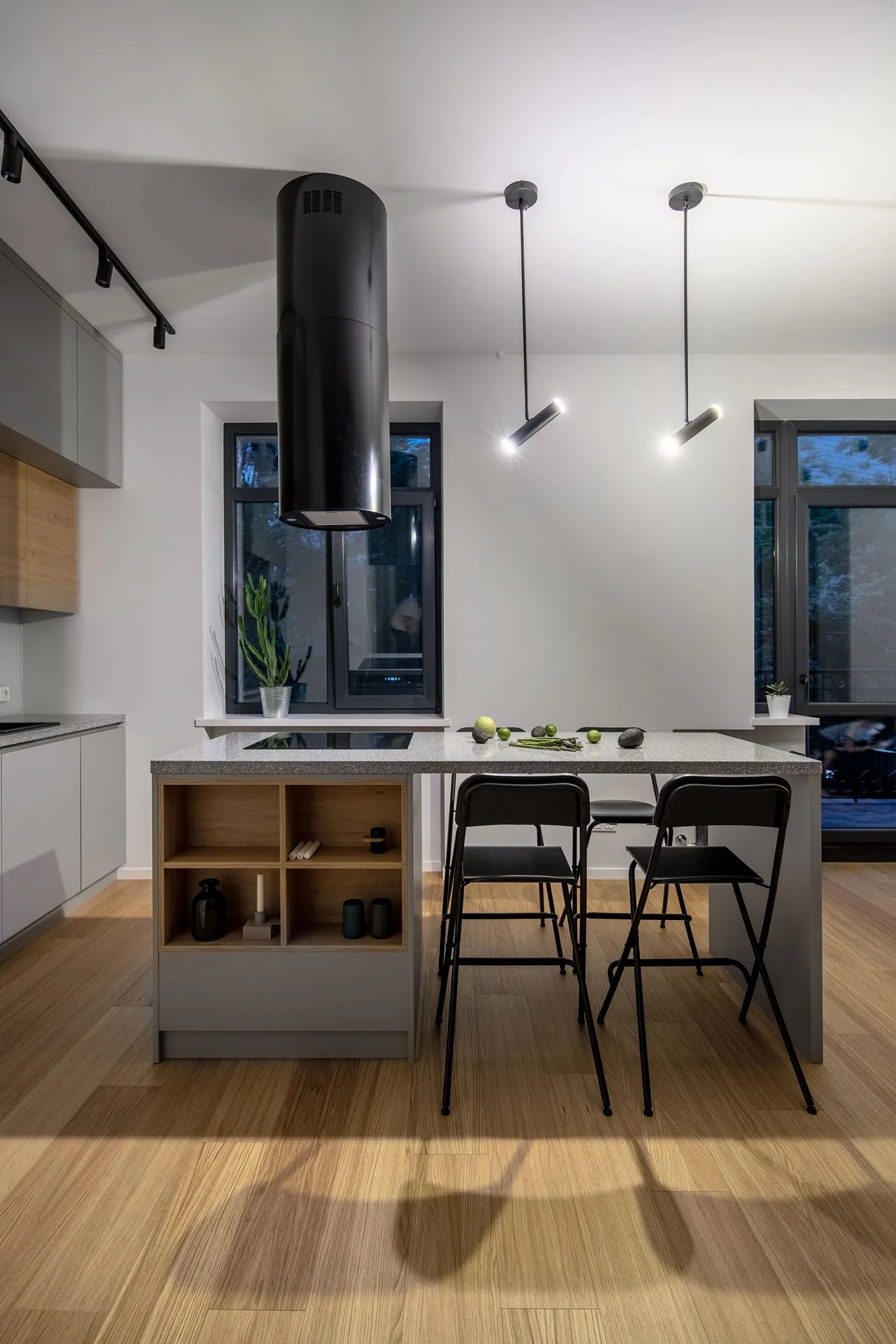 Modern kitchen interior with a marble countertop and wooden cabinets.