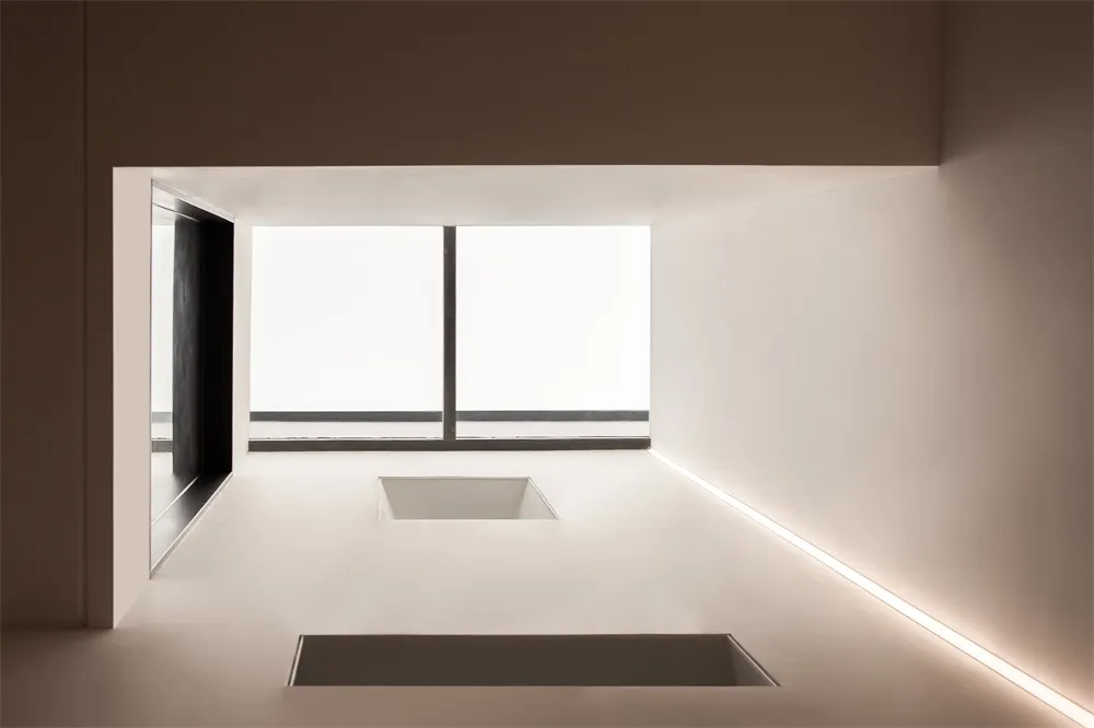 Modern minimalist interior space with concrete walls and flooring.
