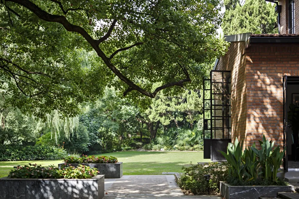 A garden with a lawn, brick walls, and greenery.