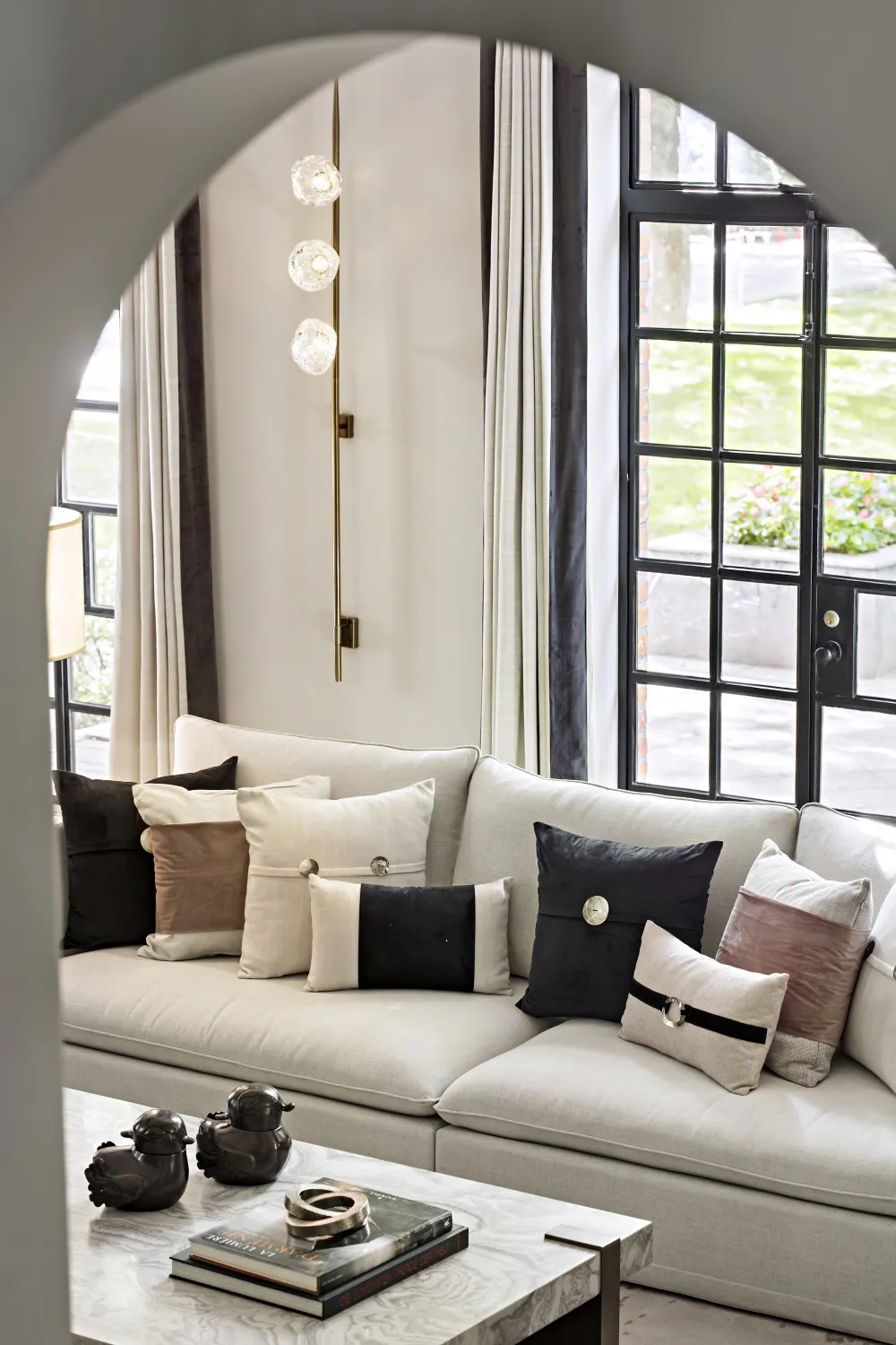 Modern residential living room with a white couch, textured marble coffee table, and glass lighting.
