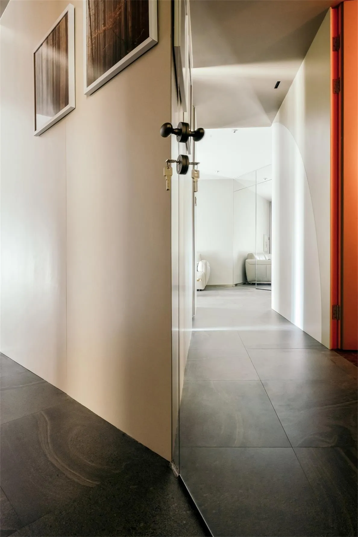 Modern corridor with white walls, minimalist decor, and dark flooring.
