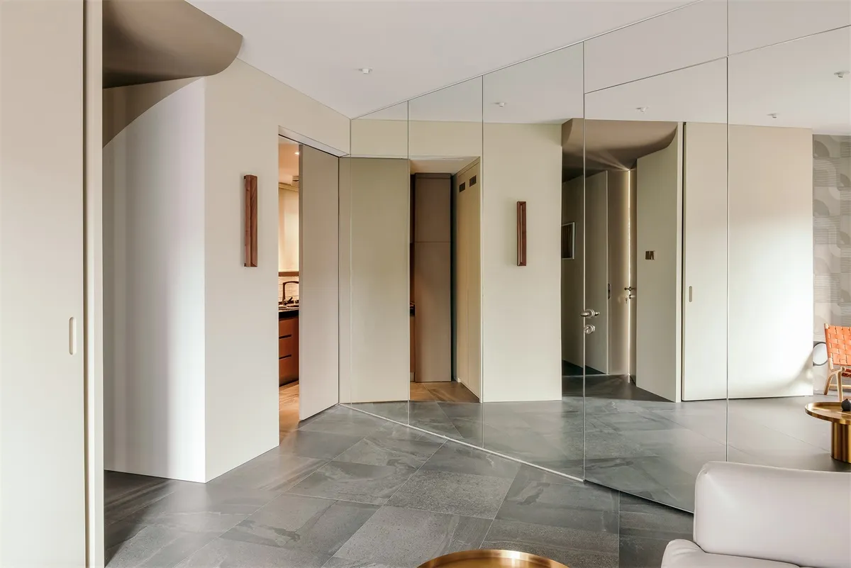 Modern living room featuring glass panel walls, minimalistic decor, and a sleek, contemporary design.