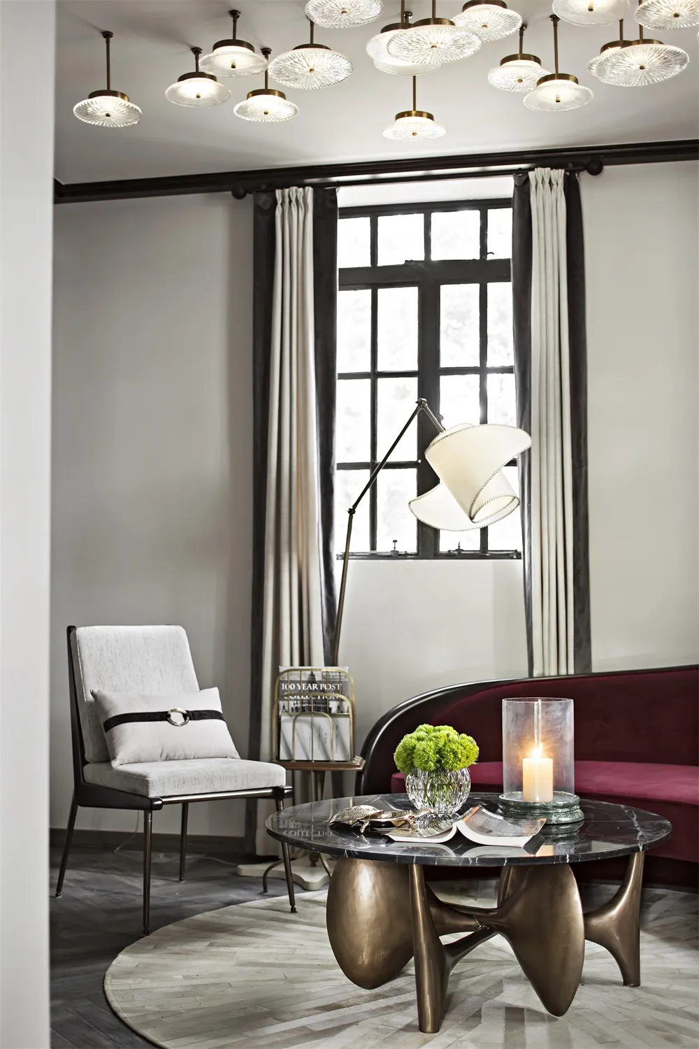 A modern living room featuring minimalist furniture, a round coffee table with a marble top, and a combination of soft and ha
