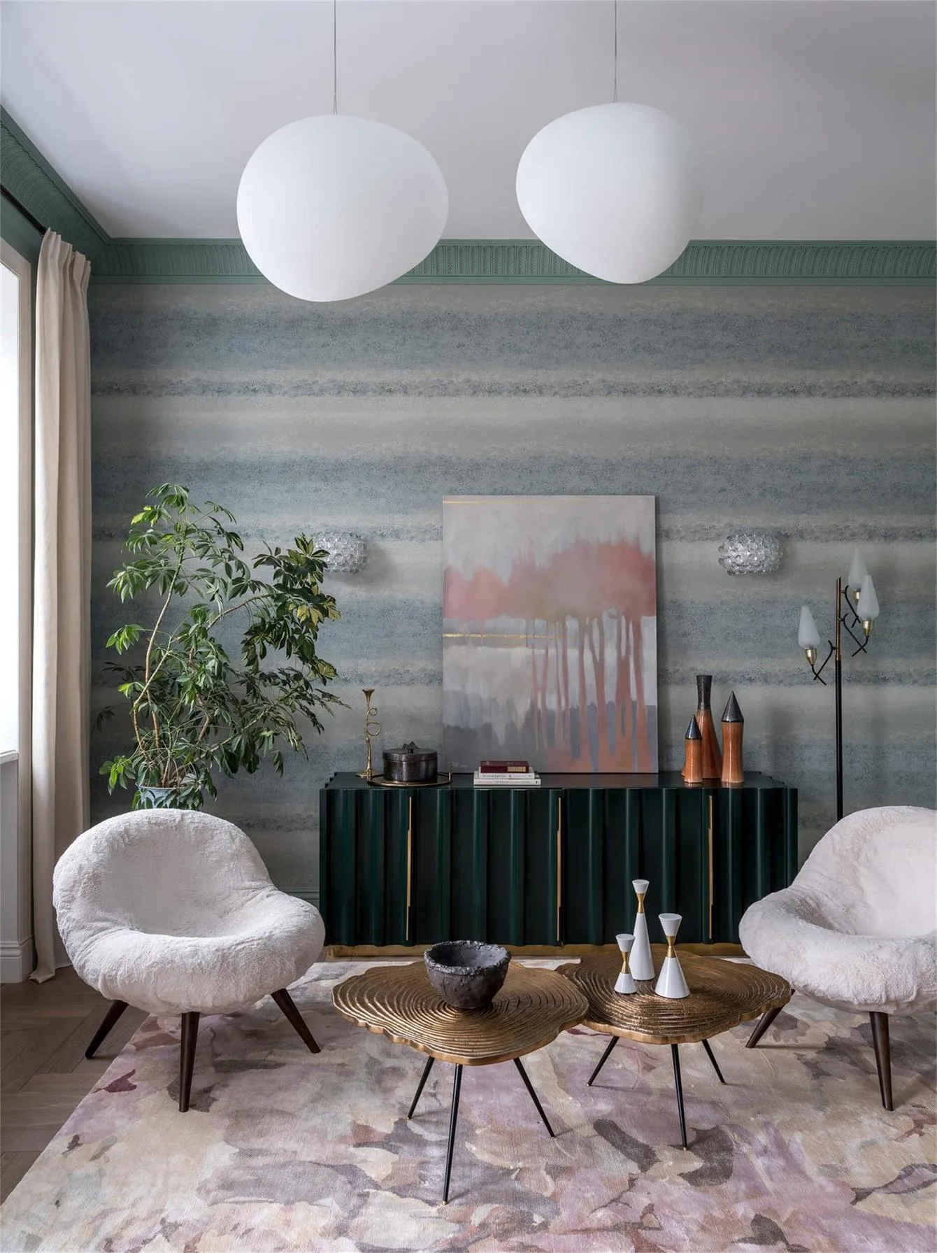 Modern living room with metallic tables, green-wood cabinet, and suede armchairs.