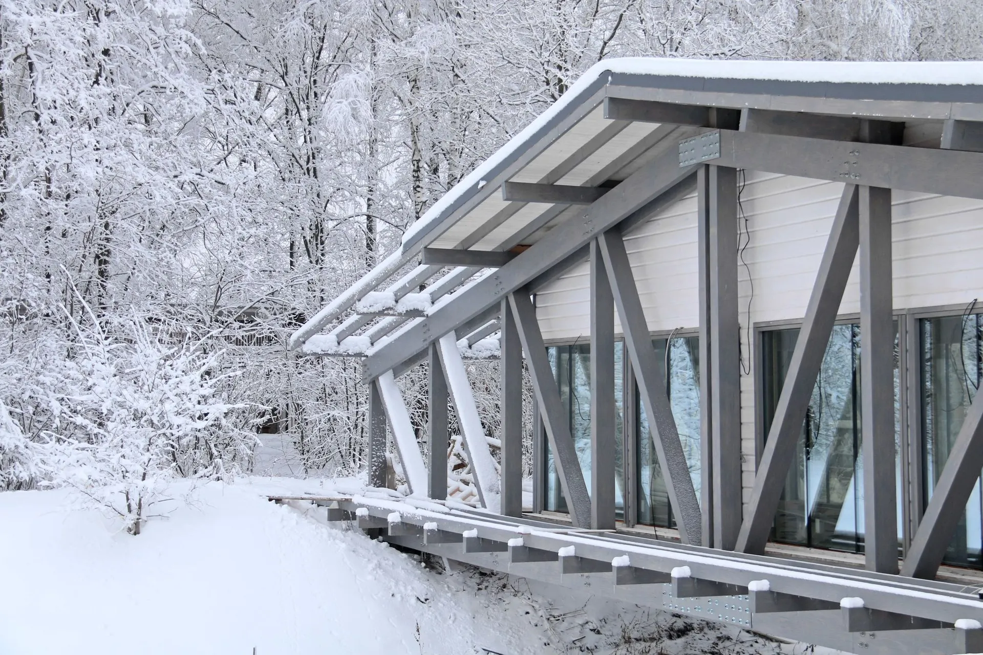 Snow-covered modern office building with metal framework beams