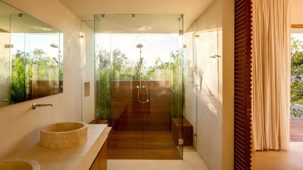 Modern minimalist bathroom featuring glass walls and concrete flooring.