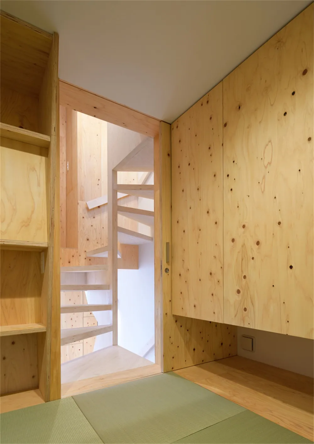 A minimalist interior space featuring wooden cabinets and shelves.