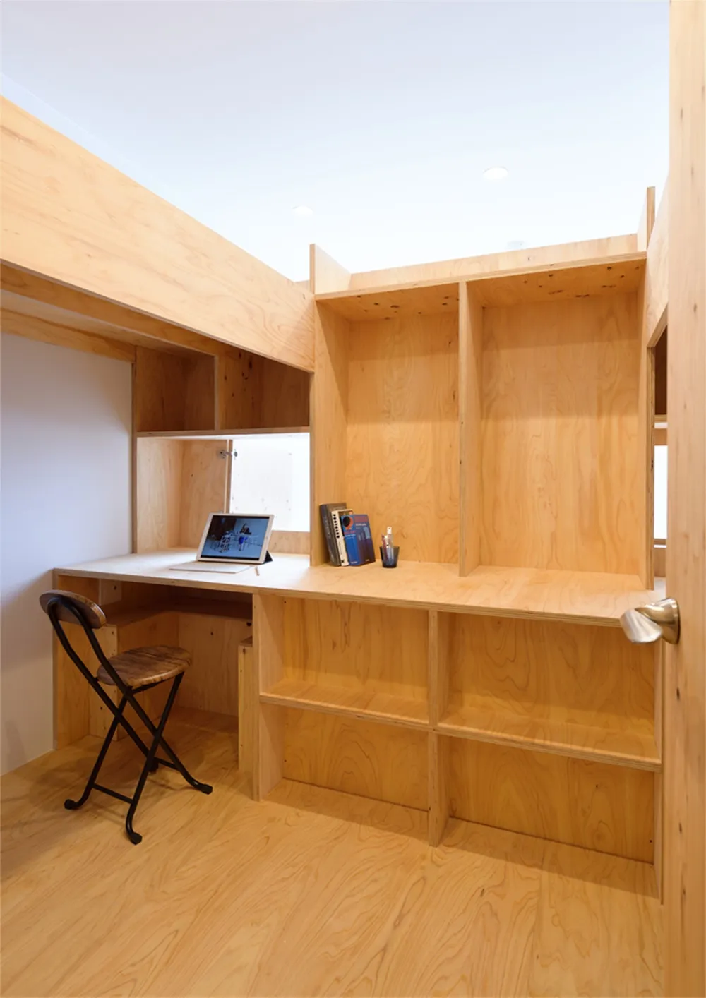 A modern home office with a wooden desk and chair.