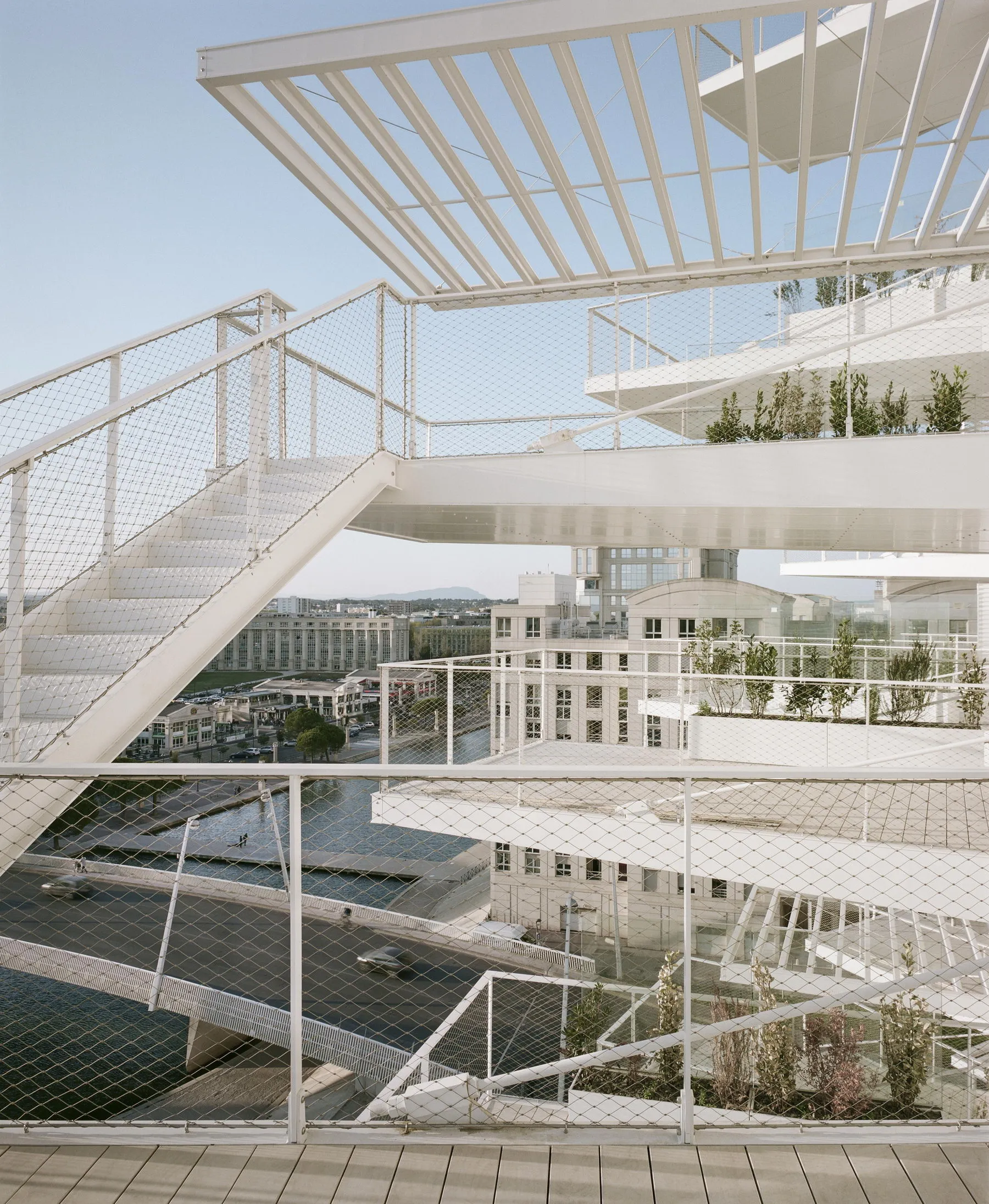 Modern outdoor space featuring metal railings and lush green plants.