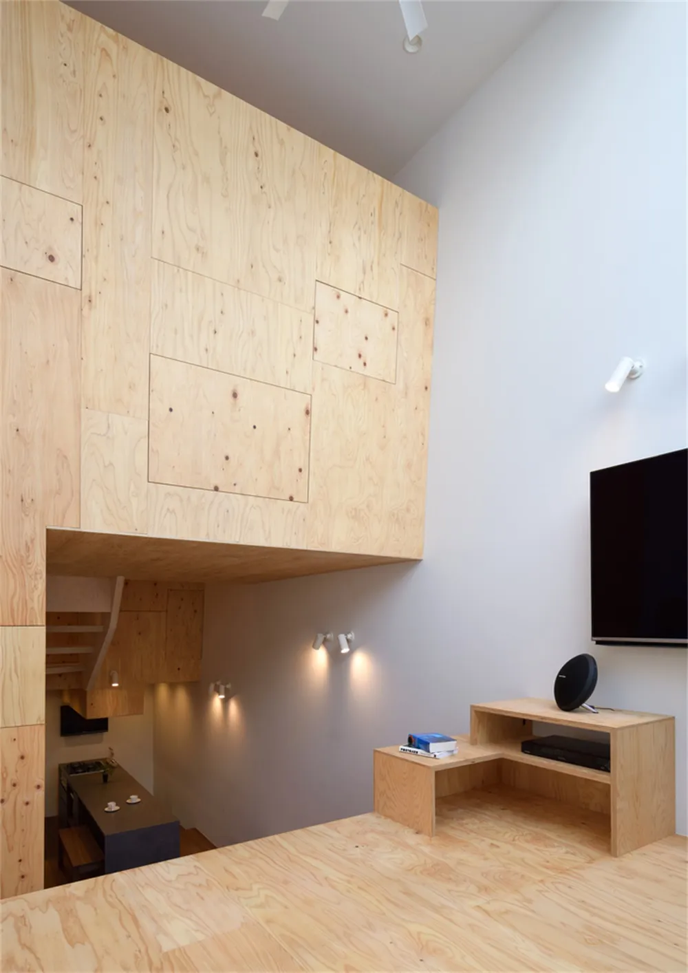 A modern living room with wooden floors, walls, and furniture.