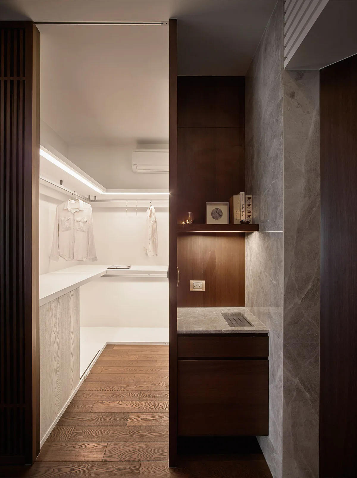 Modern closet with white marble countertops, wooden shelves, and a minimalist design.