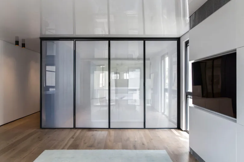 A modern minimalist room divider made of glass, featuring clean lines and a sleek design.