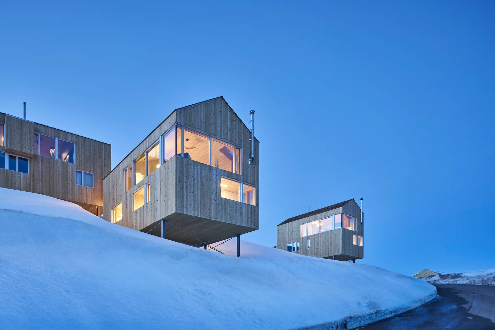 現代住宅建築採用木質外牆，地面覆滿白雪，時值黃昏