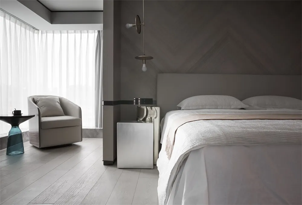 A minimalist bedroom featuring a metal panel wall, white bed, and wooden floor.