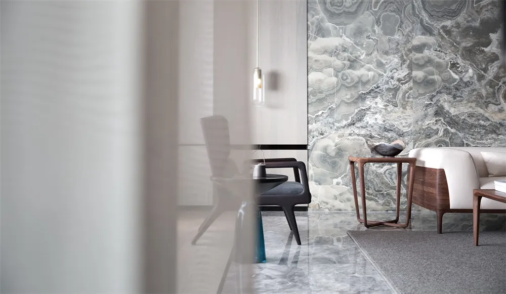 A modern living room featuring marble walls and furniture.