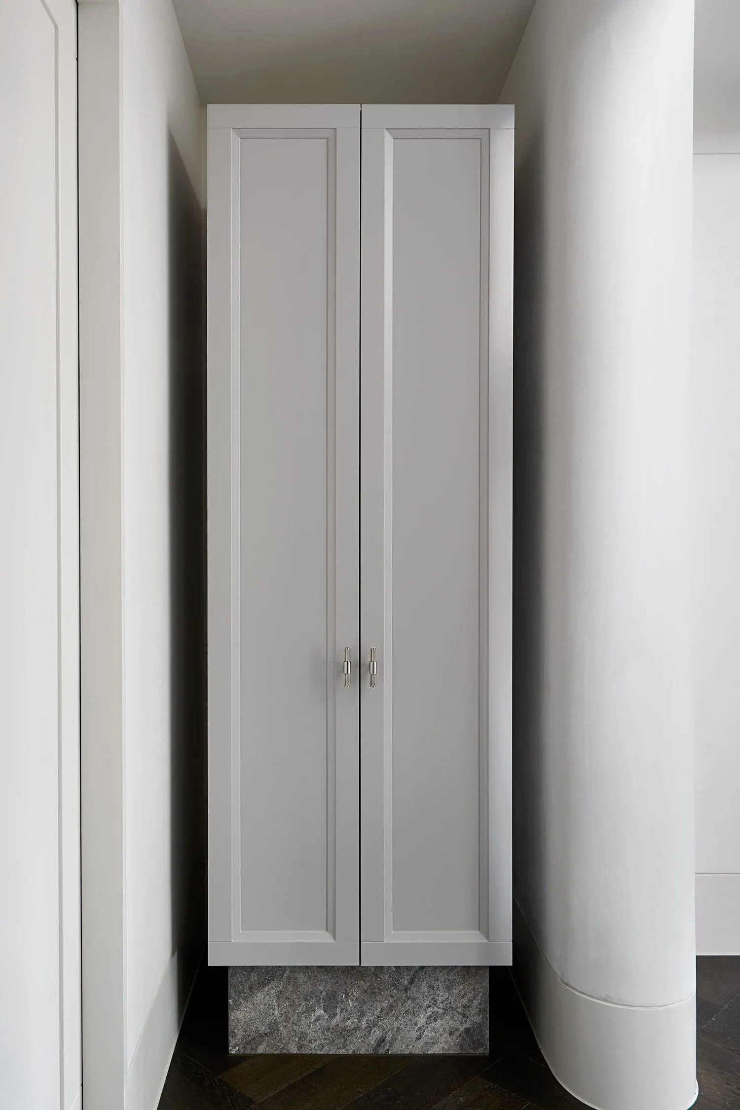 Modern interior design featuring a gray closet with concrete base, ideal for organizing clothing.