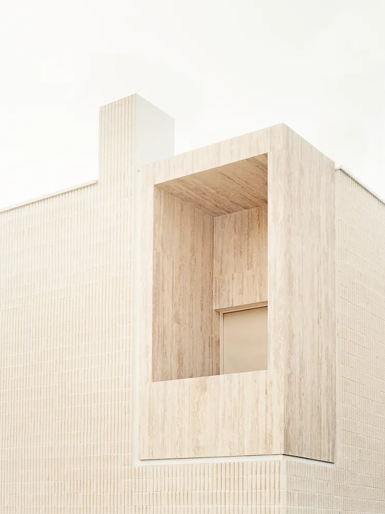 Sandstone exterior wall of a modern, minimalist building.