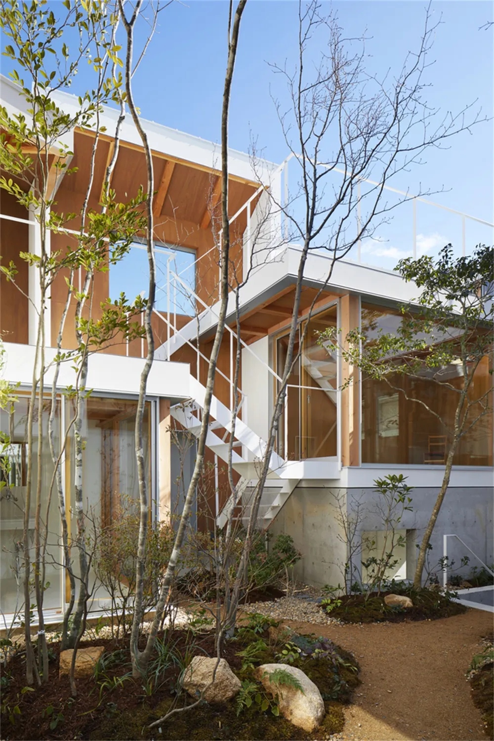 Modern architectural house with white walls, wooden elements, and glass windows.