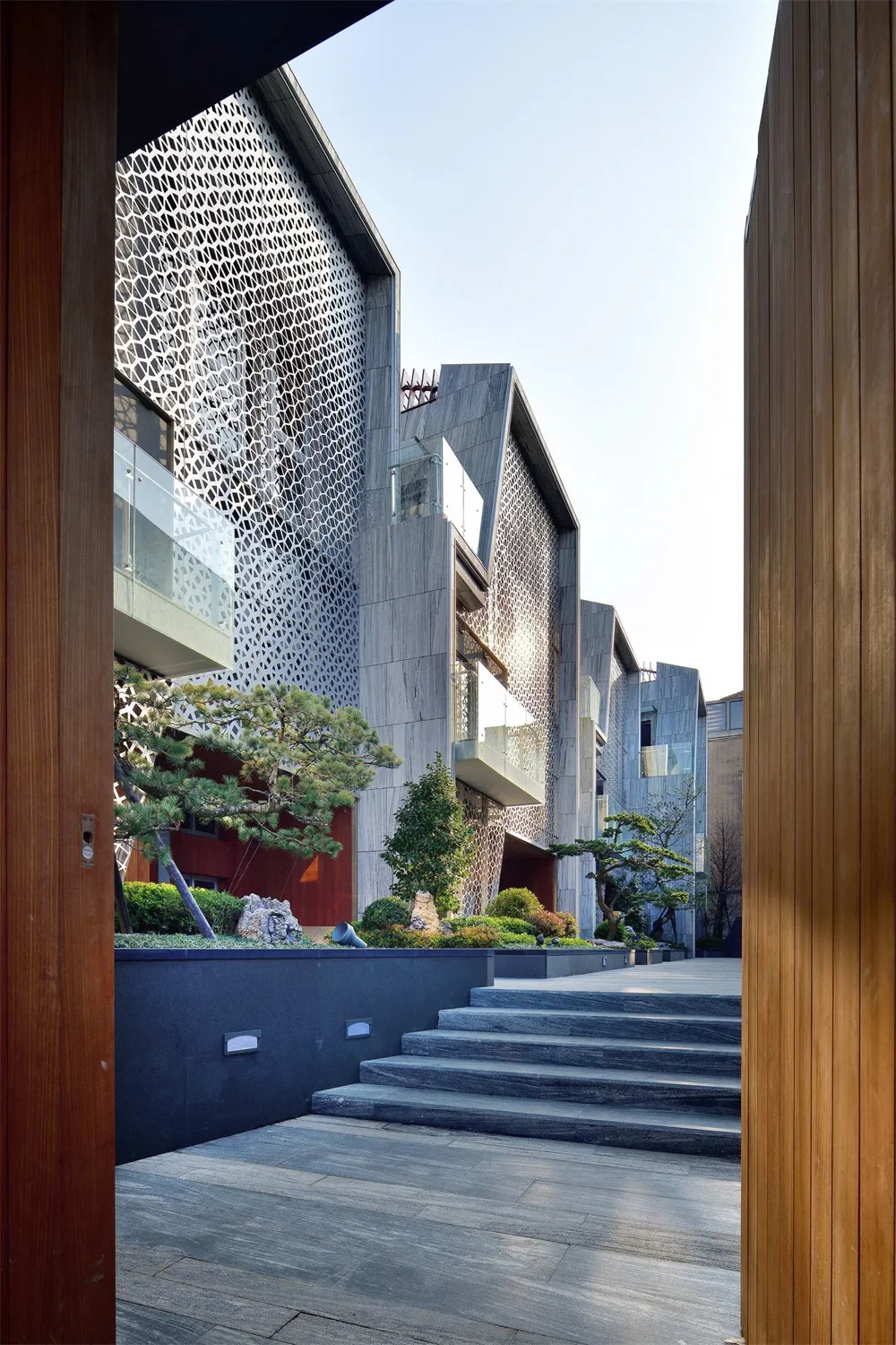 一座以金屬與石材覆層的現代建築,坐落於懸崖邊。
