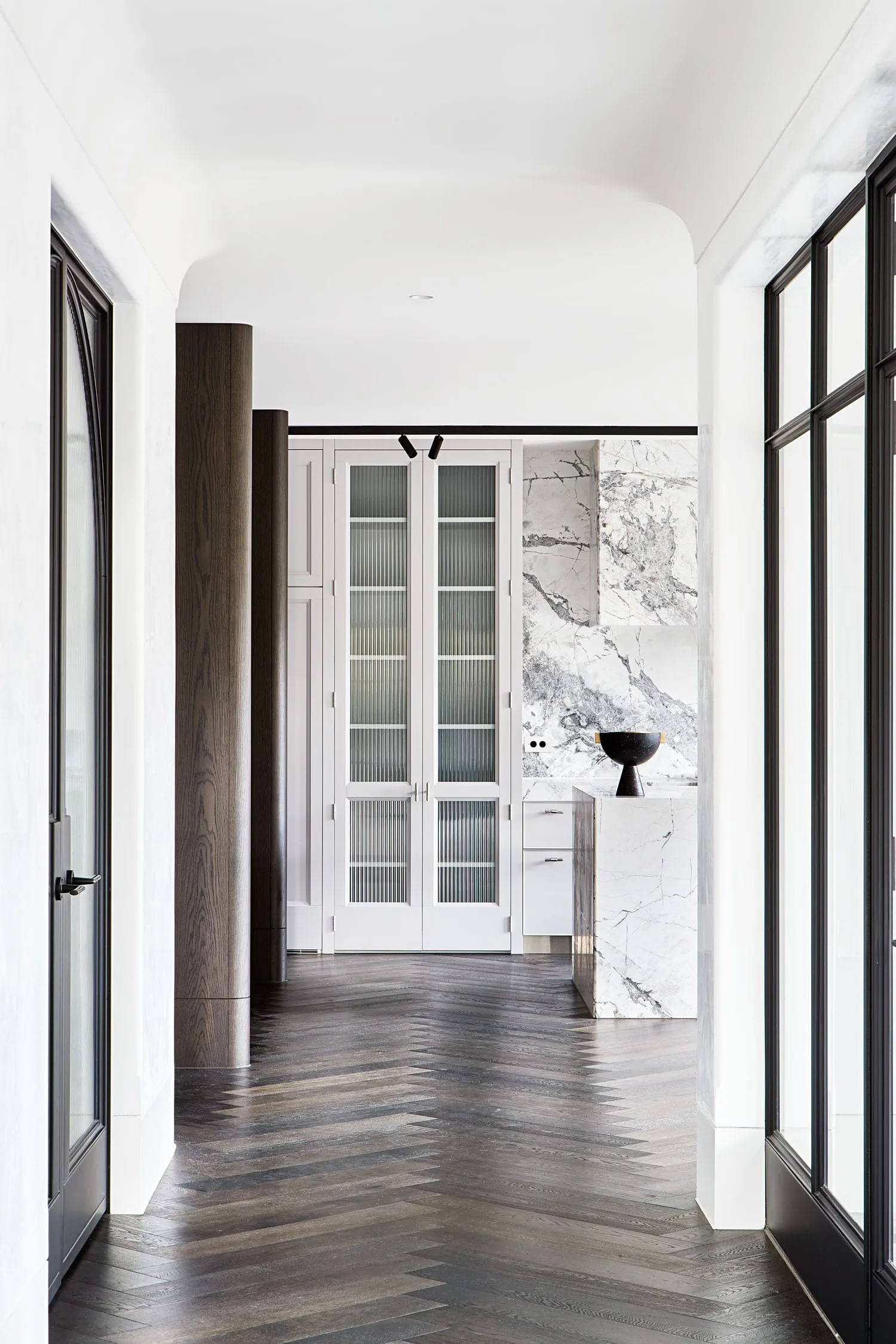 A modern interior with wooden and marble surfaces, and glass elements.