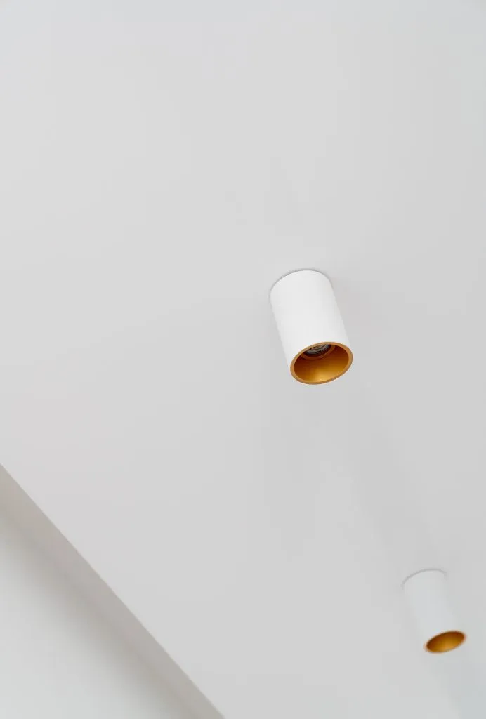 A minimalist lighting fixture mounted on a white ceiling.