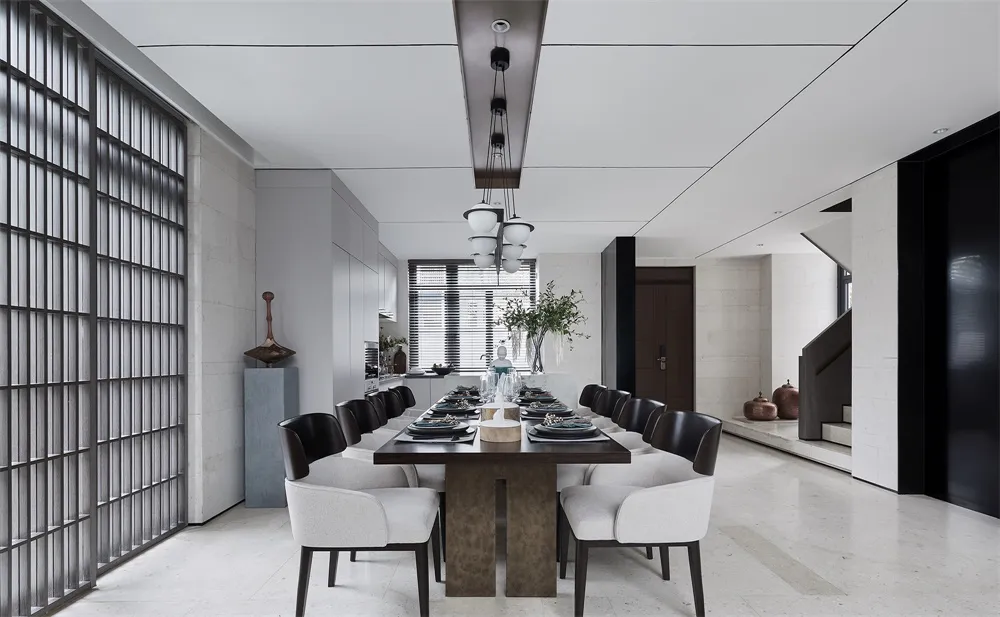 Modern dining room with a long dining table featuring a combination of concrete and glass materials.