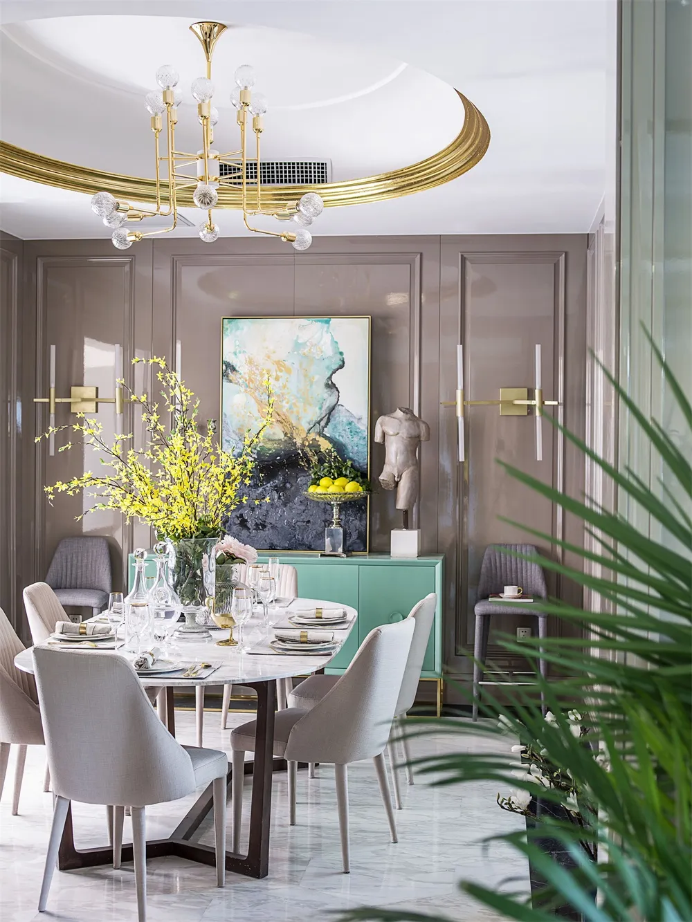 Modern dining room featuring marble table and chairs, minimalist decor, and gold chandelier.