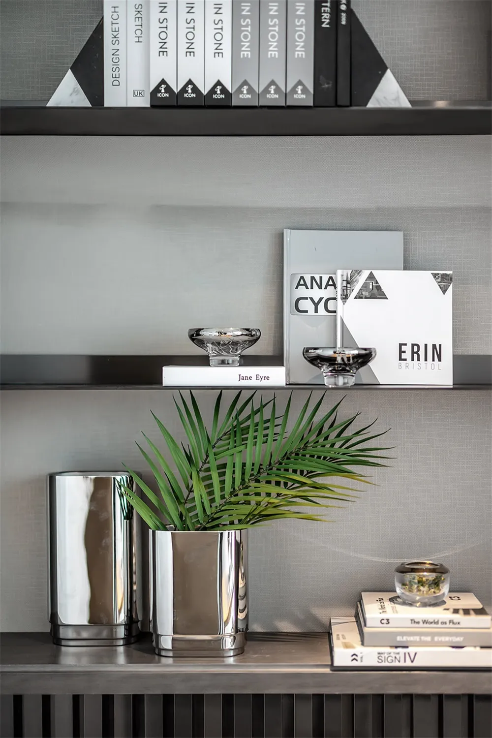 Modern, metal bookshelf display with books, plants, and decorative items.