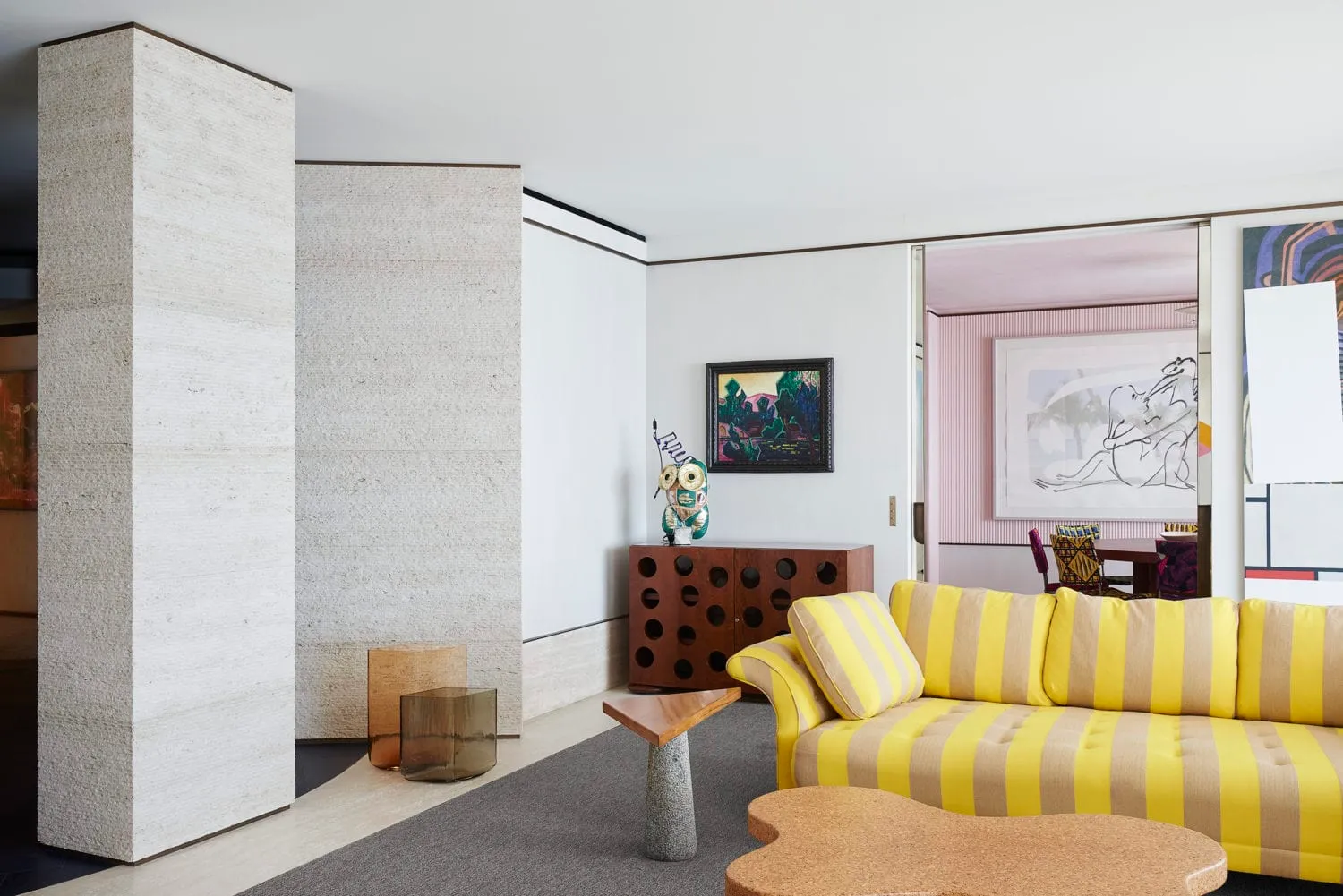 A modern living room featuring concrete walls, wooden furniture, and metal accents.