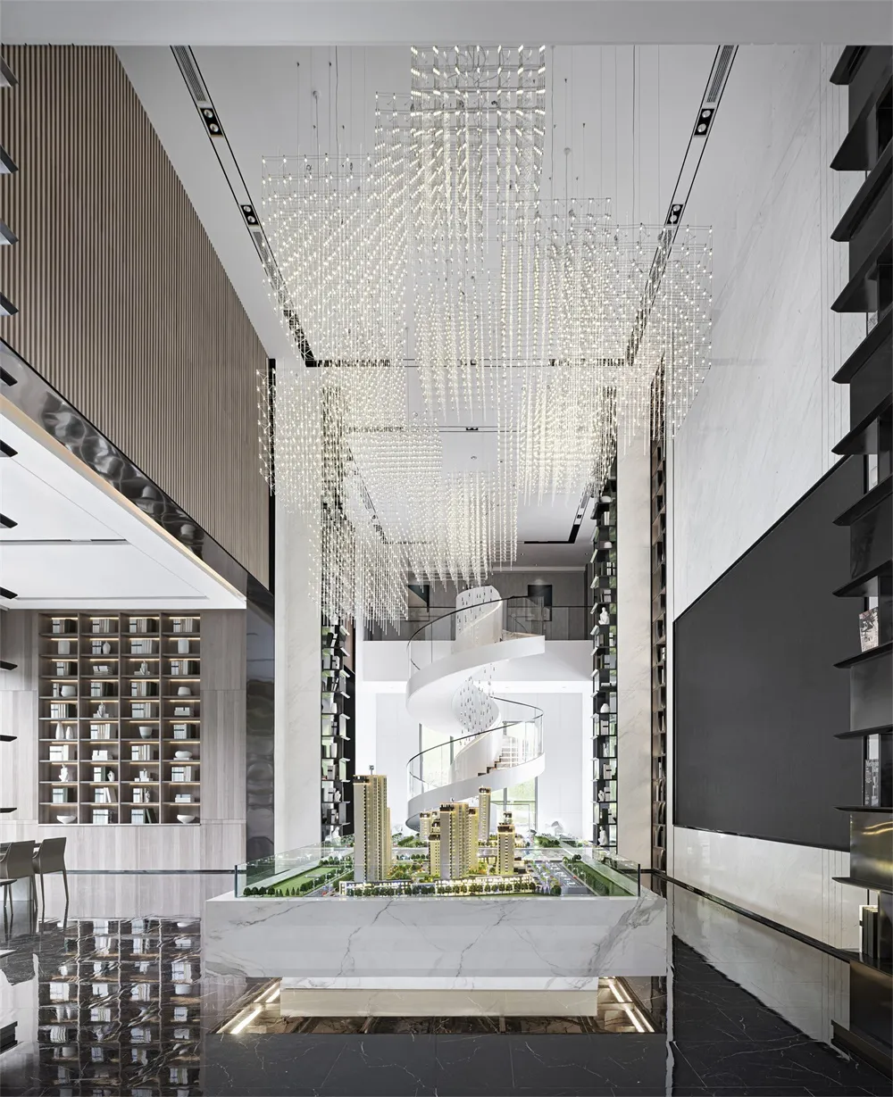 Modern lobby interior with glass chandeliers, marble accents, and metal spiral staircase.