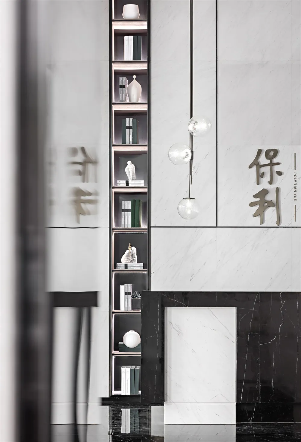 現代客廳以流暢大理石裝飾為特色，搭配擺滿書籍與裝飾品的書架，以及一盞吊燈