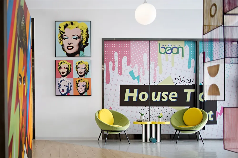 A modern restaurant interior featuring colorful geometric patterns and vibrant yellow chairs.
