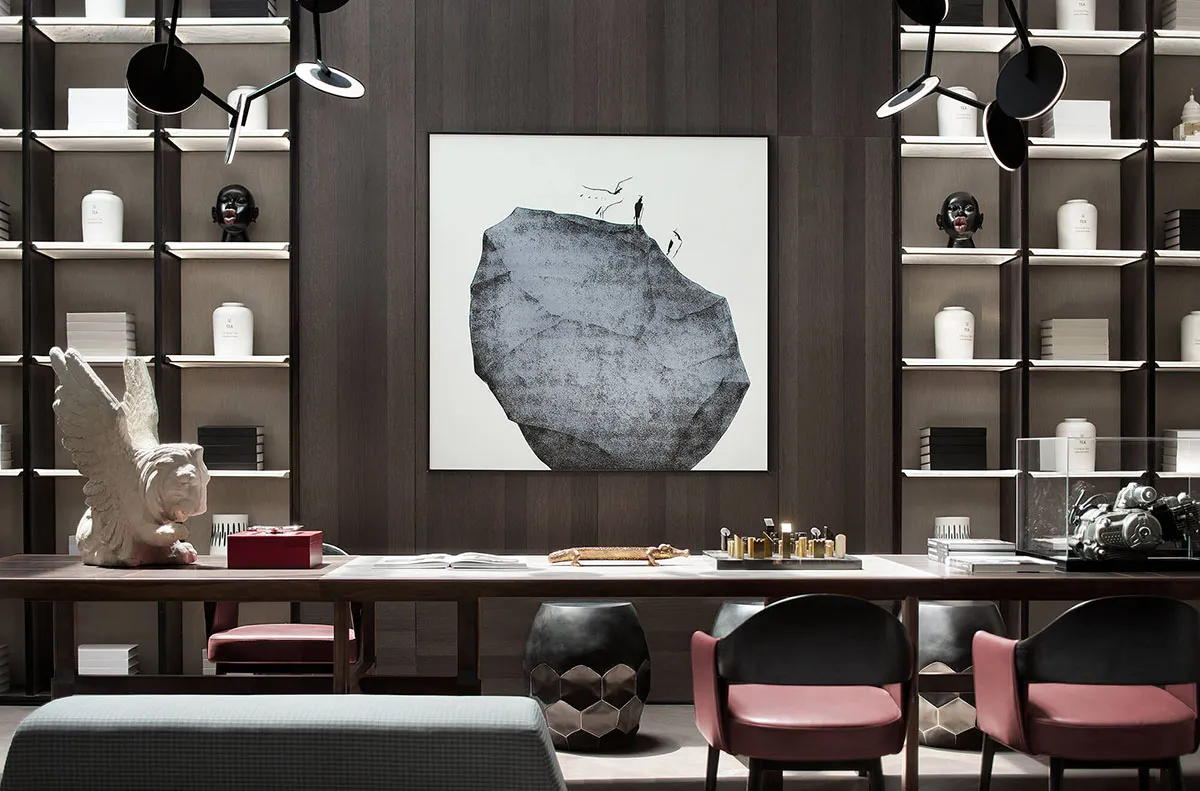 A modern home office featuring a large bookshelf, desk, and seating area with a minimalist and stylish design.